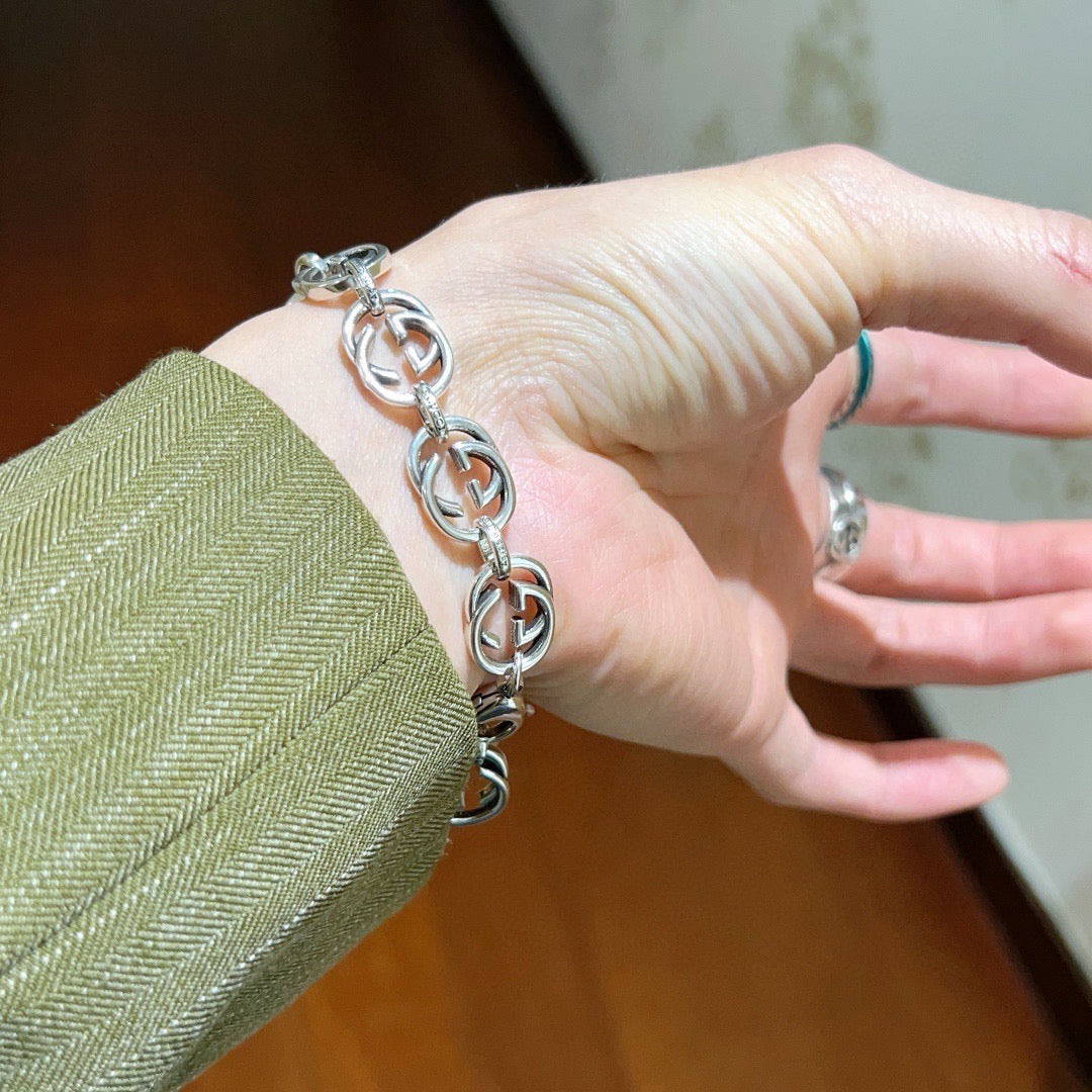 Silver-tone chunky link bracelet on hand, interlocking oval links