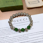 Silver beaded bracelet with green beads shown on a thank-you card