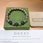 Silver bead bracelet with green round beads and engraved spacers on box
