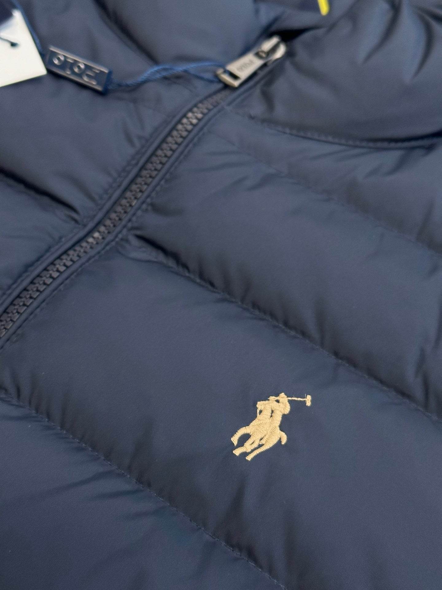Ralph Lauren puffer jacket chest area, navy blue with gold polo logo