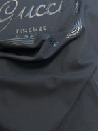 Dark navy T-shirt fabric close-up with partial Gucci and Firenze print