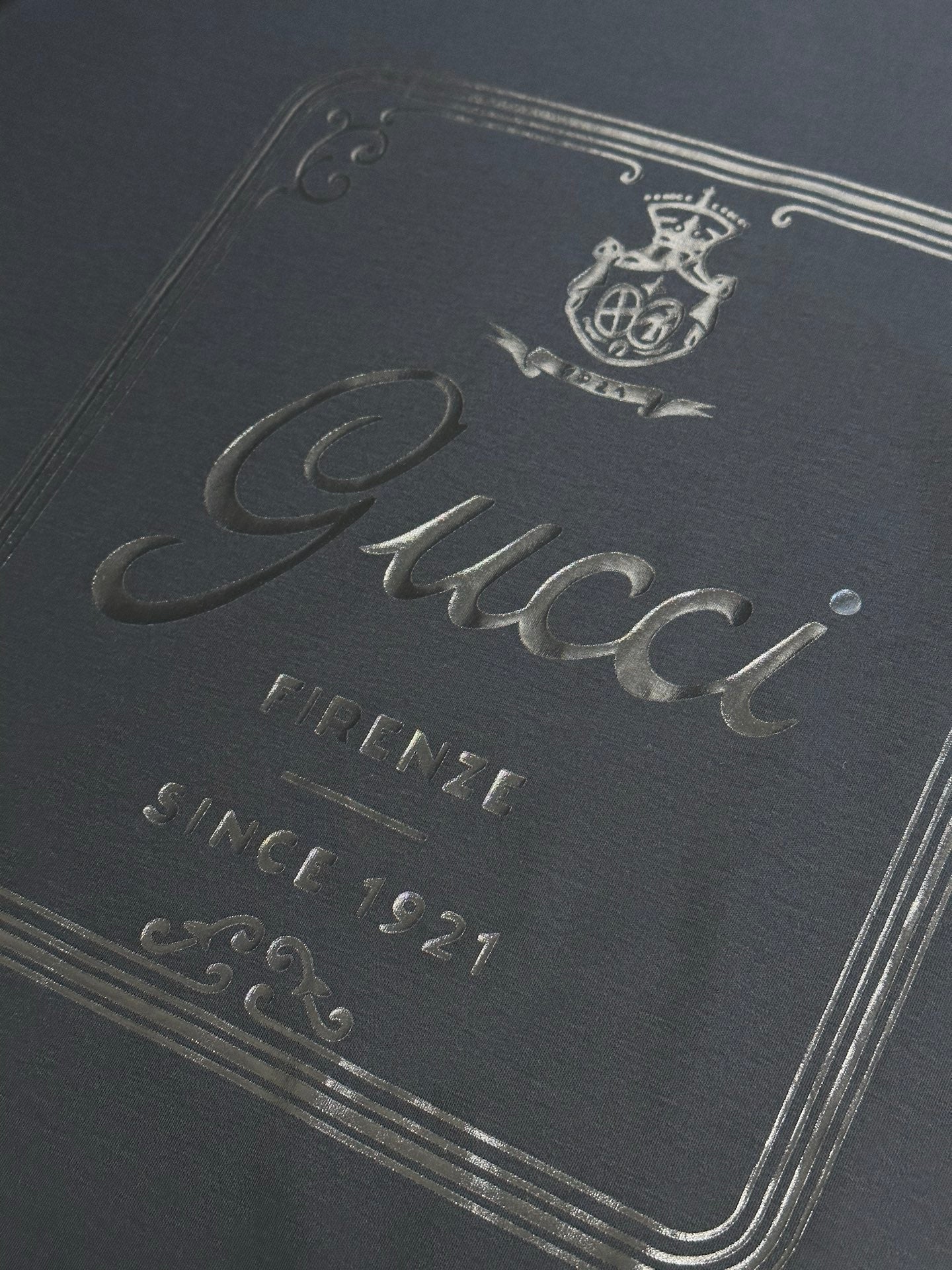 Dark navy T-shirt close-up of Gucci script with Firenze and Since 1921 text