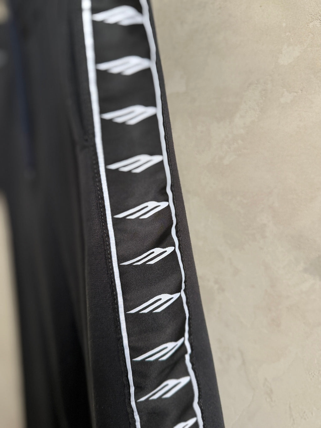Dark navy pants with white repeating logo stripe along the side panel.