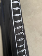 Dark navy pants with white repeating logo stripe along the side panel.