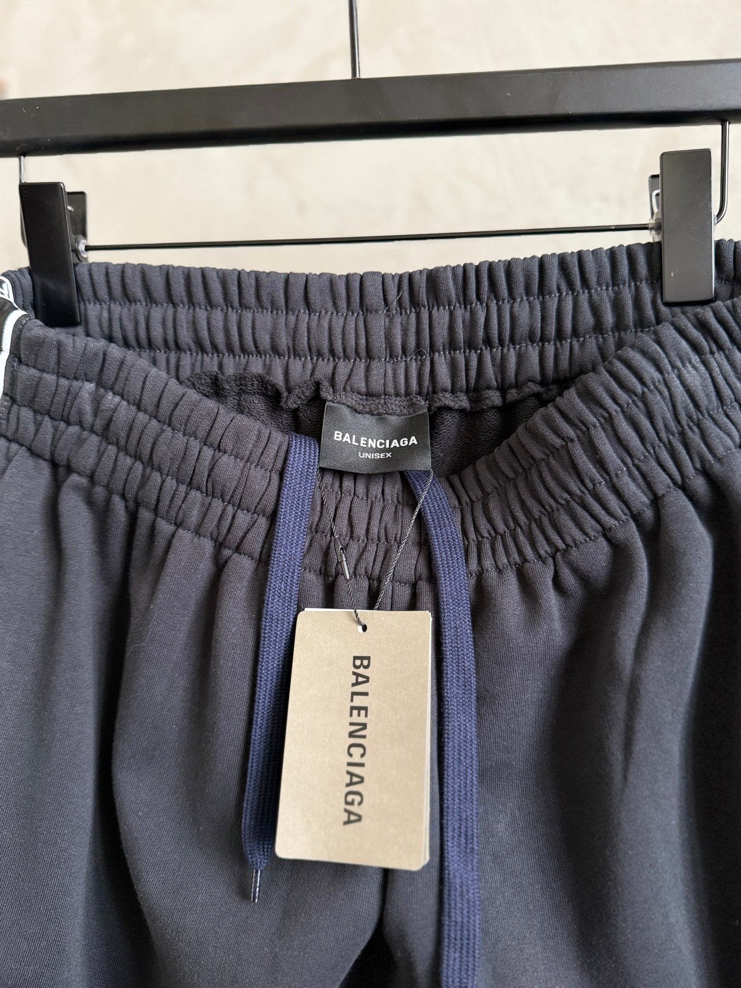 Dark navy pants with elastic waistband, drawcord, and Balenciaga label tag.