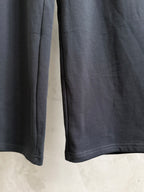 Dark navy wide-leg pants with visible side seam and curved hem edge.