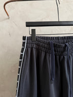 Dark navy drawstring pants with gathered elastic waist and tie.