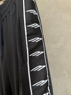 Dark navy pants with white repeating logo stripe and black stitched side seam.