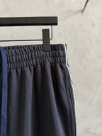 Dark navy pants with elastic waistband and gathered fabric at the top hem.