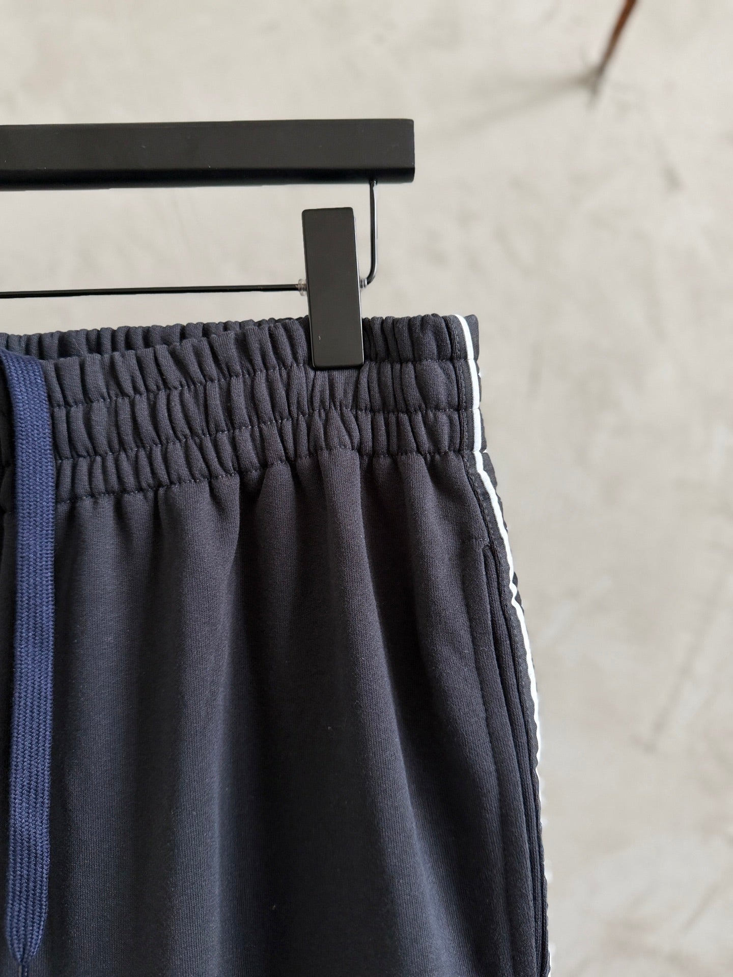 Dark navy pants with elastic waistband and gathered fabric at the top hem.