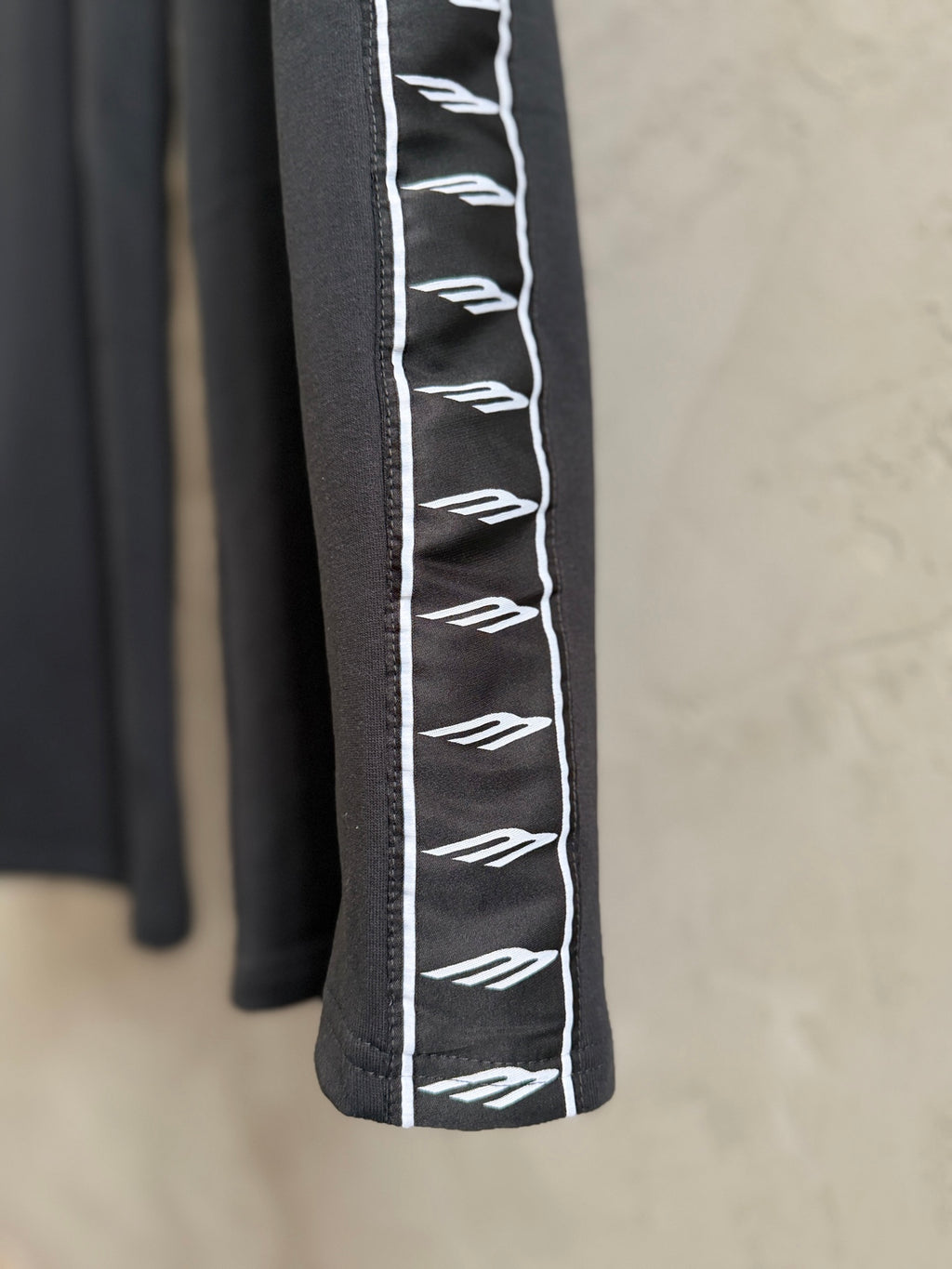 Black pants with white logo stripe detail on the side seam