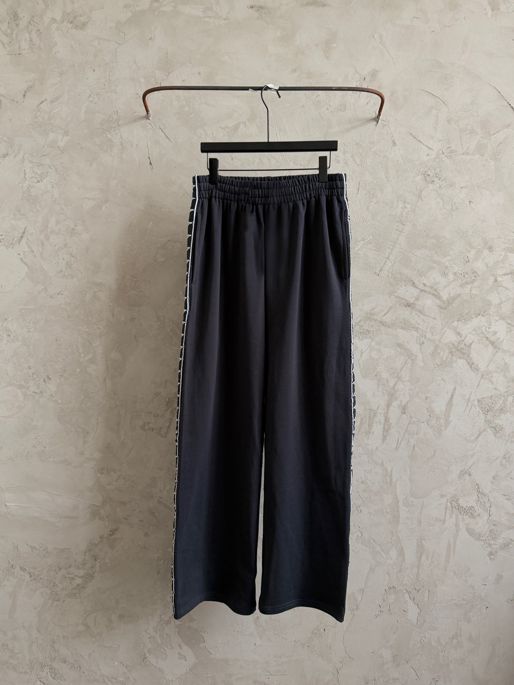 Black elastic-waist pants hanging on a hanger
