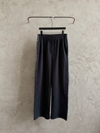 Black elastic-waist pants hanging on a hanger