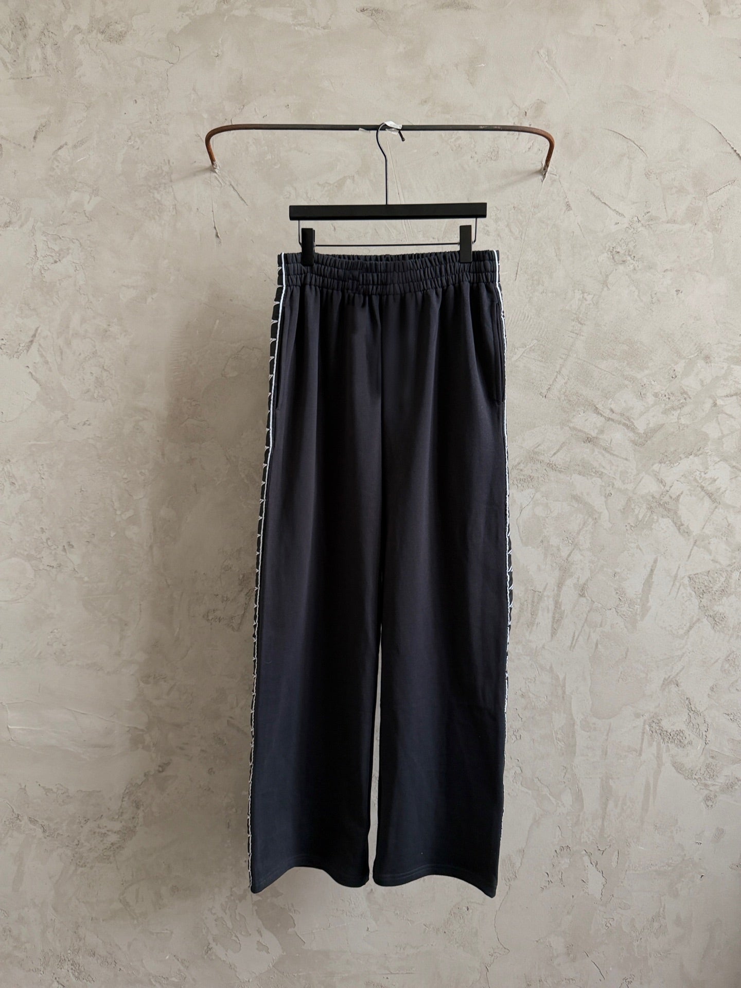 Black elastic-waist pants hanging on a hanger