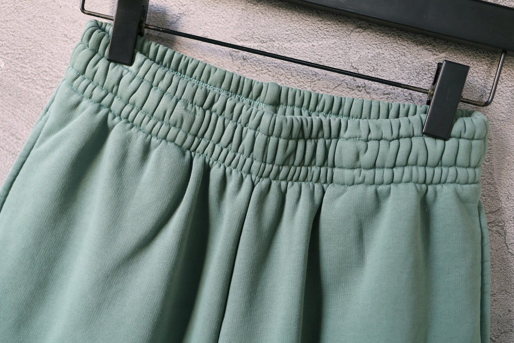 Teal shorts waistband with gathered elastic and belt-loop details