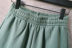 Teal shorts waistband with gathered elastic and belt-loop details