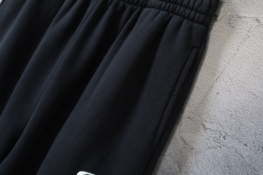 Black pants with gathered elastic waist and stitched fold details