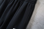 Black pants with gathered elastic waist and stitched fold details