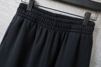 Black pants with elastic waistband and pleated front drape