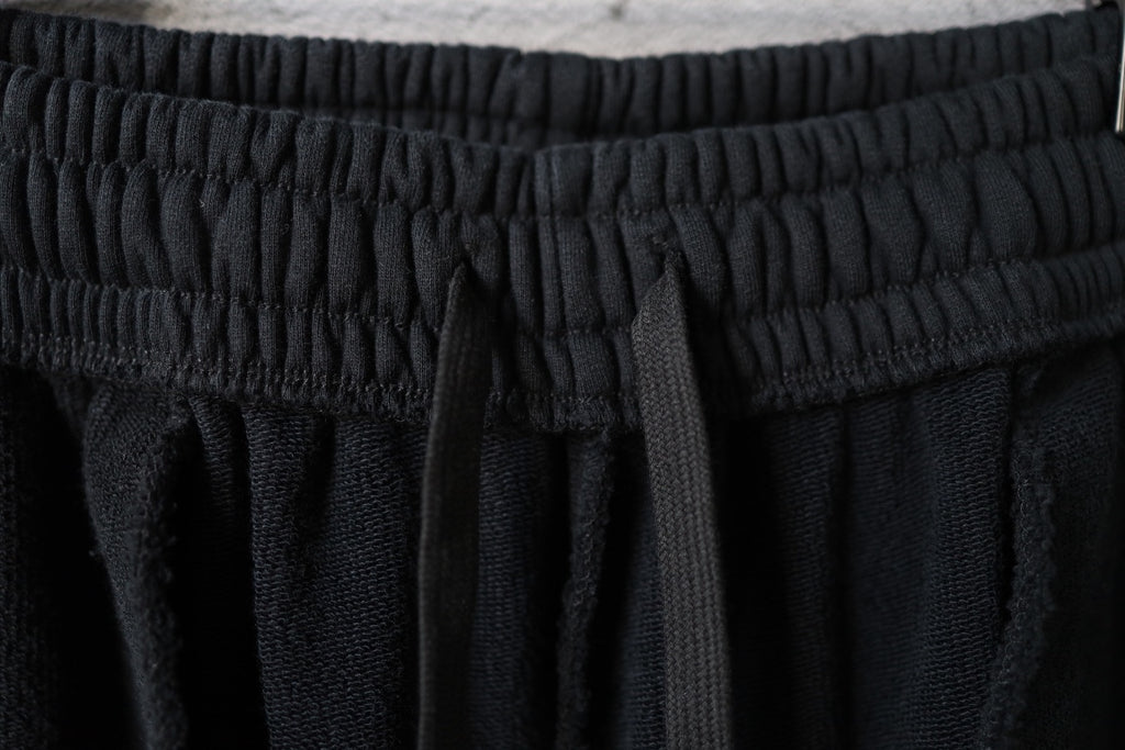Black pants with textured elastic waistband and stitched seams