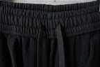Black pants with textured elastic waistband and stitched seams