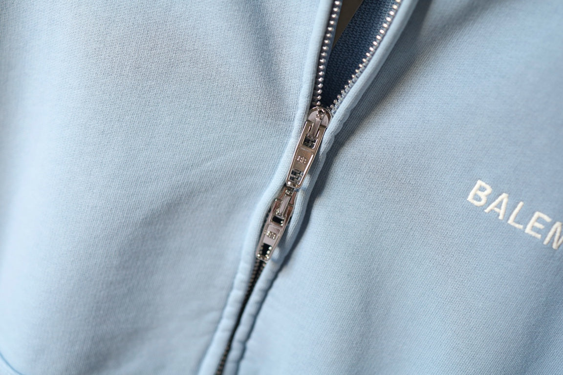 Light blue hoodie close-up: silver zipper teeth and BALENCIAGA logo