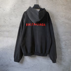 Black hooded sweatshirt with large red Balenciaga logo on back