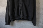 Black hoodie with kangaroo pocket and drawstring-like front center seam; zip front.