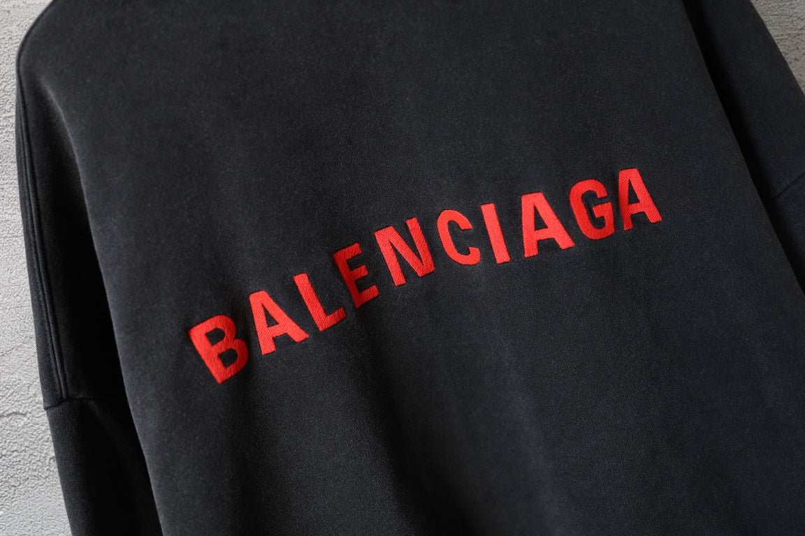Red Balenciaga logo across black hoodie back