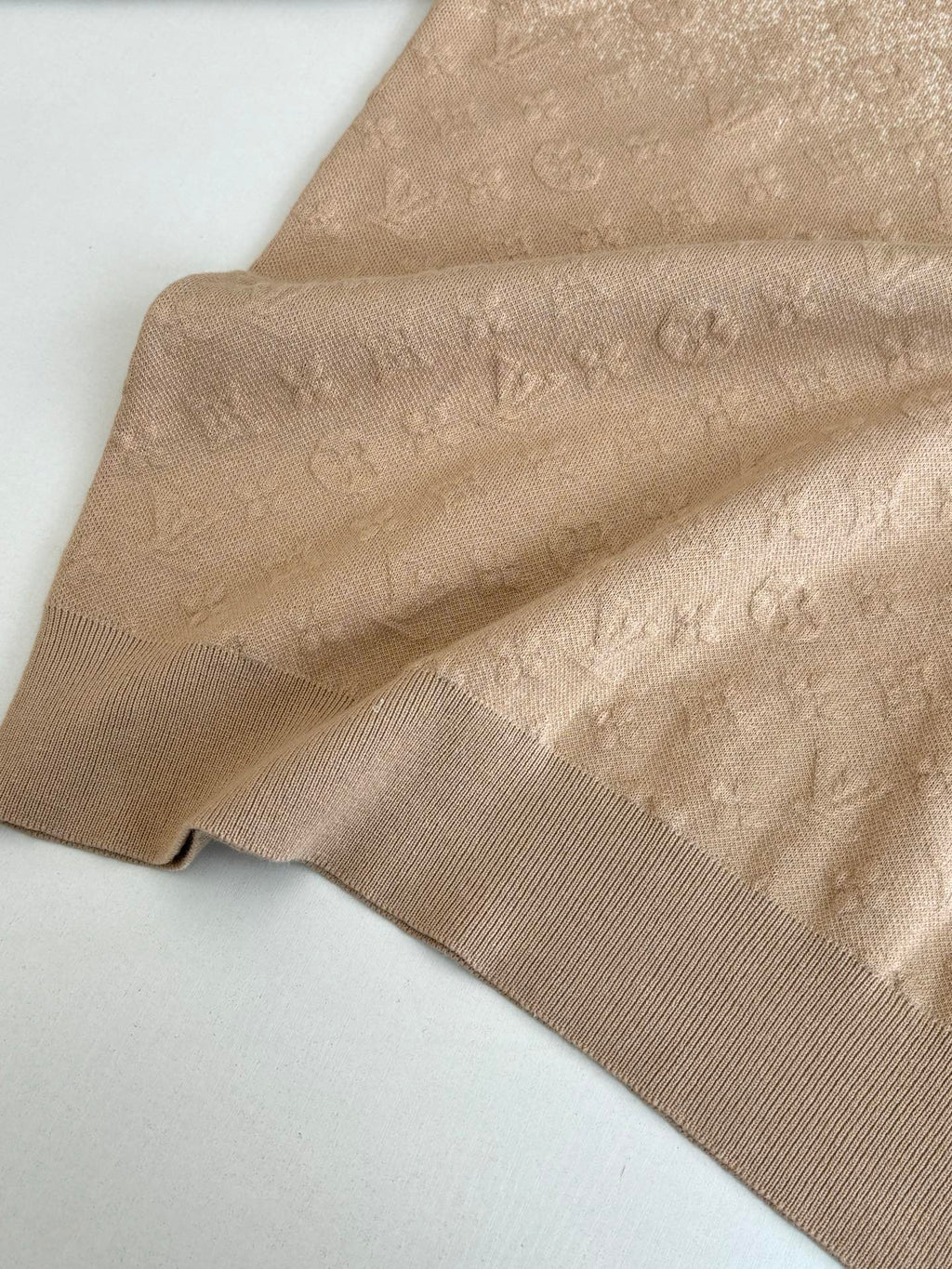 Light beige monogram knit sweater fabric close-up