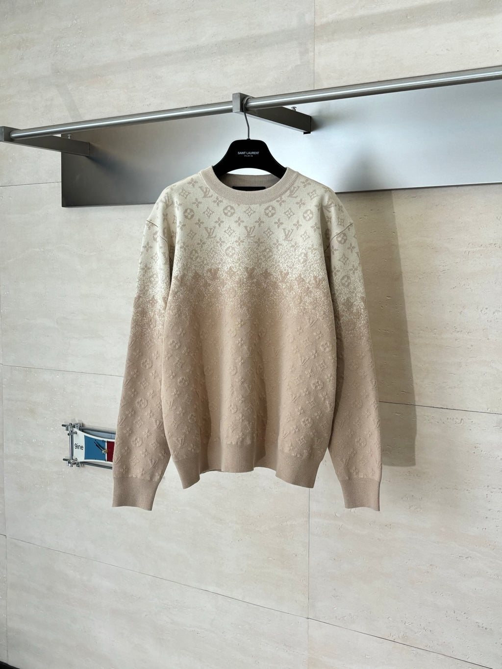 Light beige monogram long-sleeve sweater on hanger