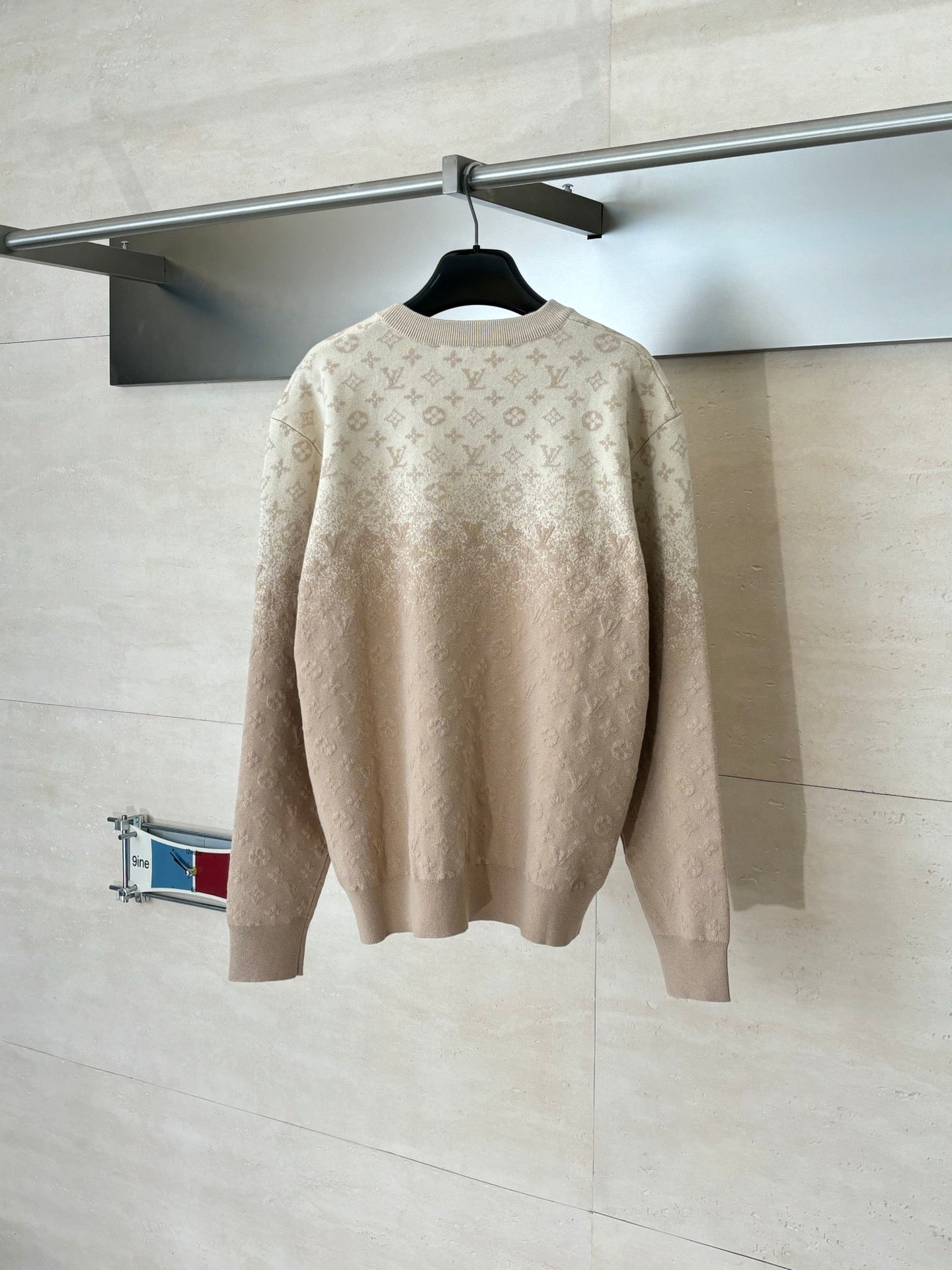 Light beige monogram long-sleeve sweater, back view on hanger