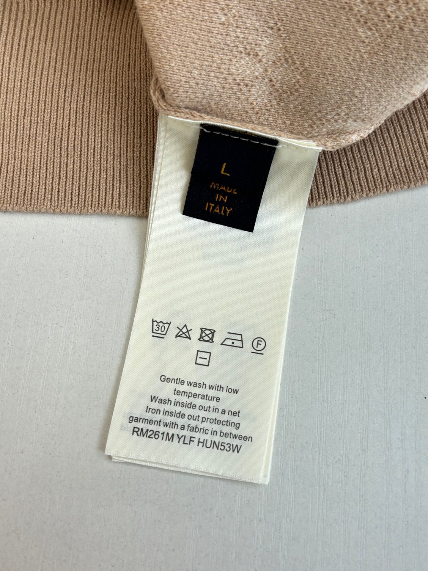 Light beige sweater care label on inside hem