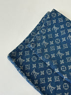 Louis Vuitton blue monogram denim shorts close-up, showing fabric texture and repeating pattern.