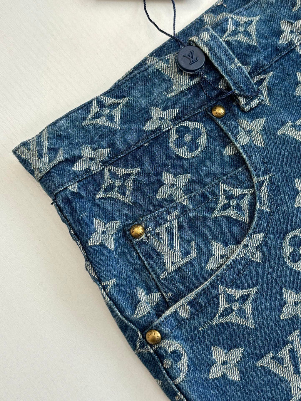 Louis Vuitton blue monogram denim shorts detail, button fly and belt loops.