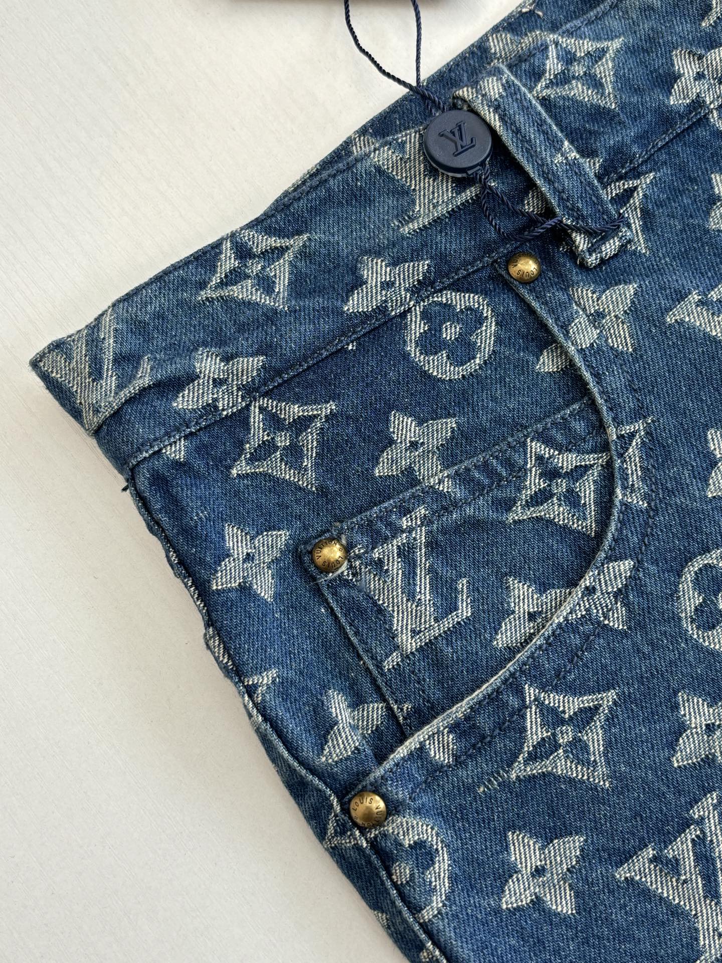 Louis Vuitton blue monogram denim shorts detail, button fly and belt loops.