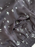 Detail of dark navy shorts: drawstring, button front, and small white motif print