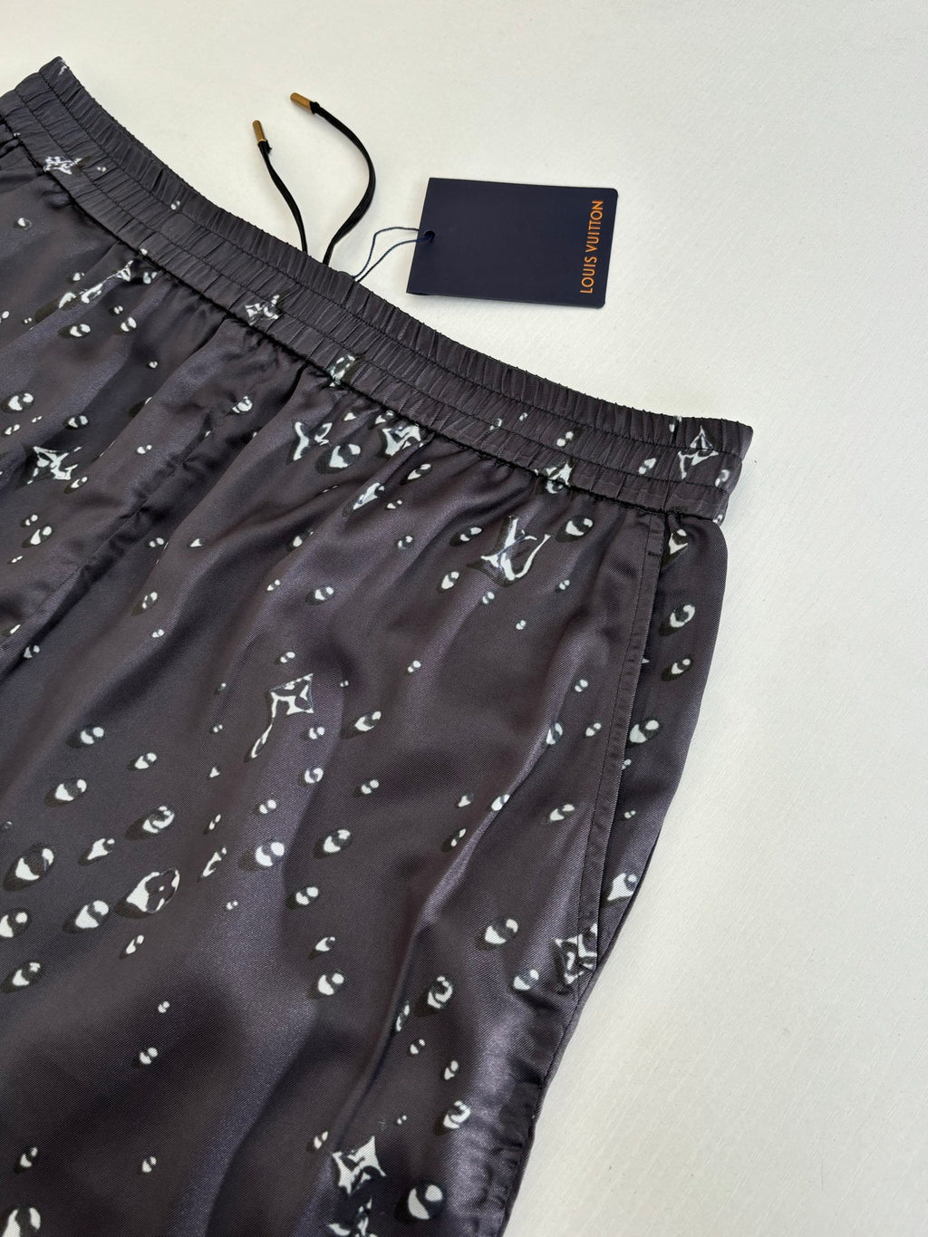 Close-up of dark navy patterned shorts with elastic waistband and small white motifs