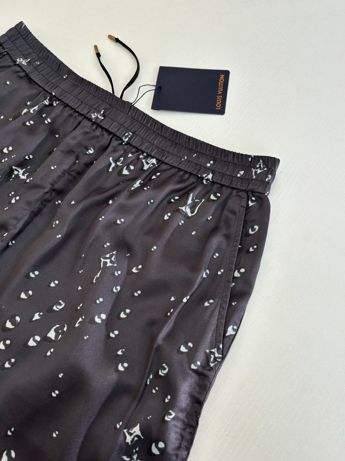 Close-up of dark navy patterned shorts with elastic waistband and small white motifs