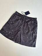 Dark navy printed shorts with elastic waistband, drawstring ties, and small white motifs