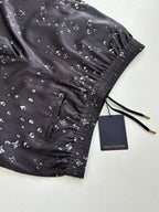 Dark navy printed shorts with black drawstring ties and elastic cuff at hem