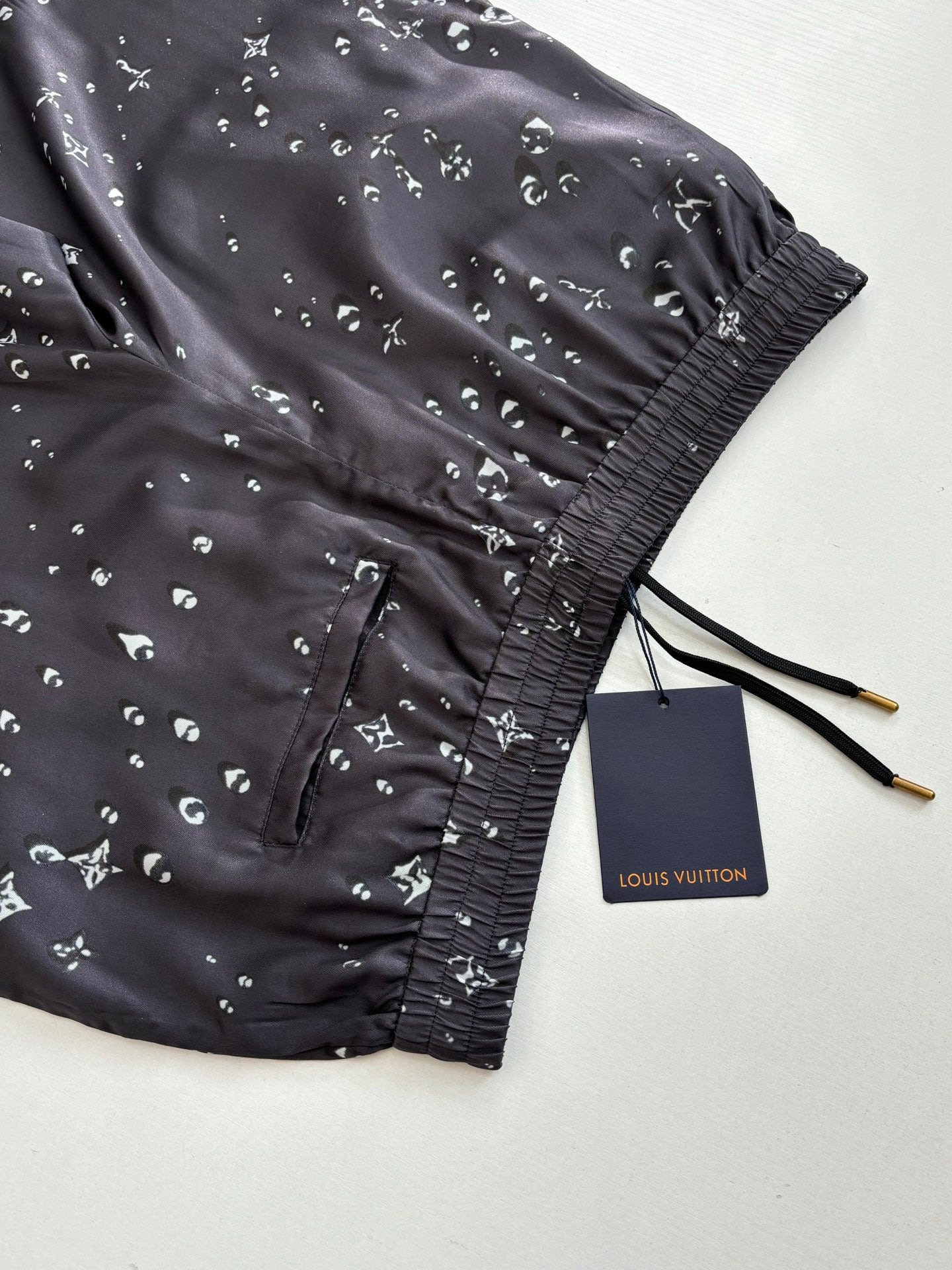 Dark navy printed shorts with black drawstring ties and elastic cuff at hem