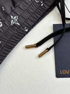 Drawstring and label detail on dark navy printed shorts with gold-toned aglets