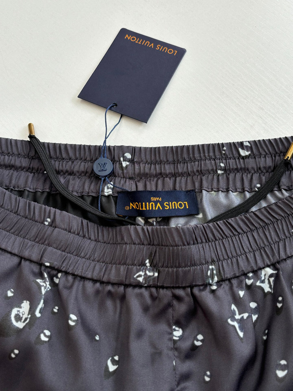 Waistband detail of dark navy printed shorts with elastic band and interior label