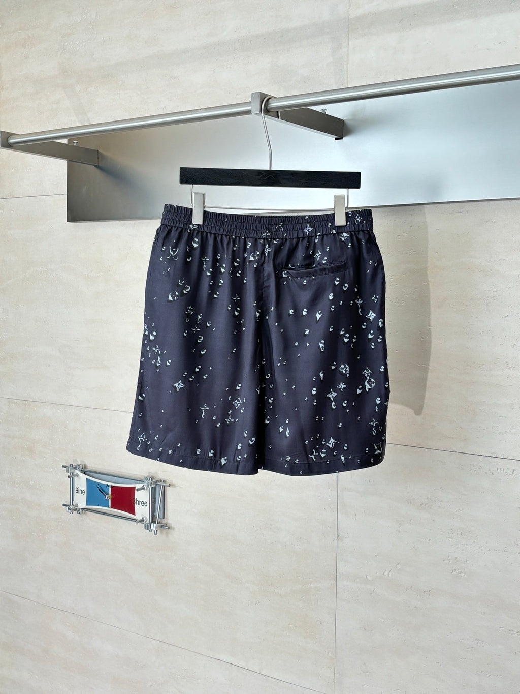 Dark navy printed shorts with elastic waistband and small white motif pattern