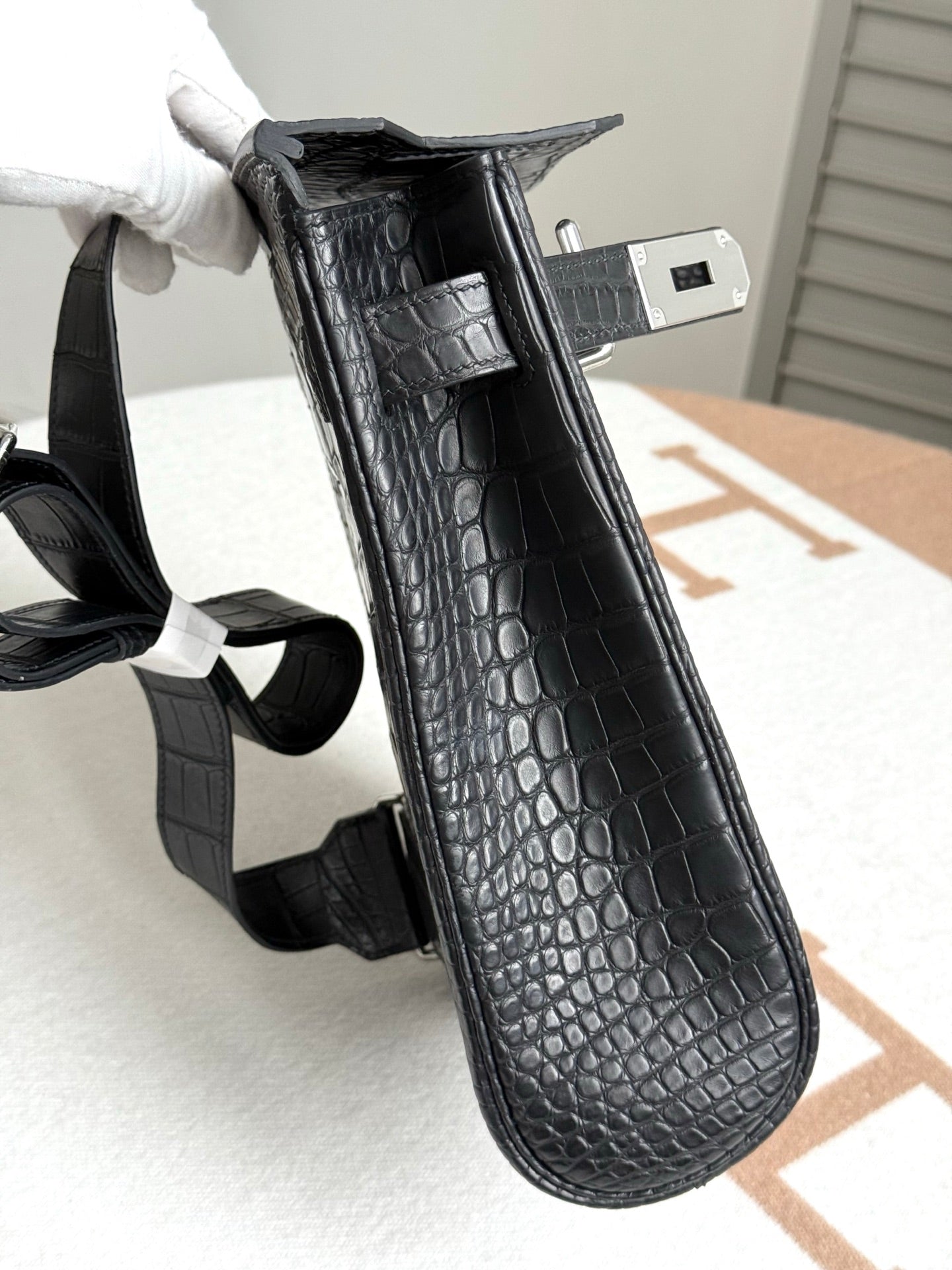 Hermes dark crocodile-embossed leather handbag shown in angled side view