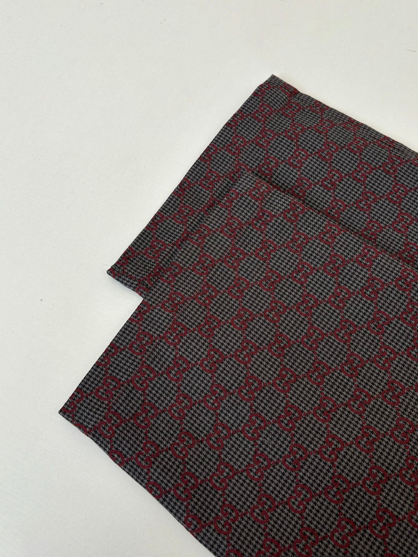 Gucci patterned pants, folded fabric showing dense allover pattern
