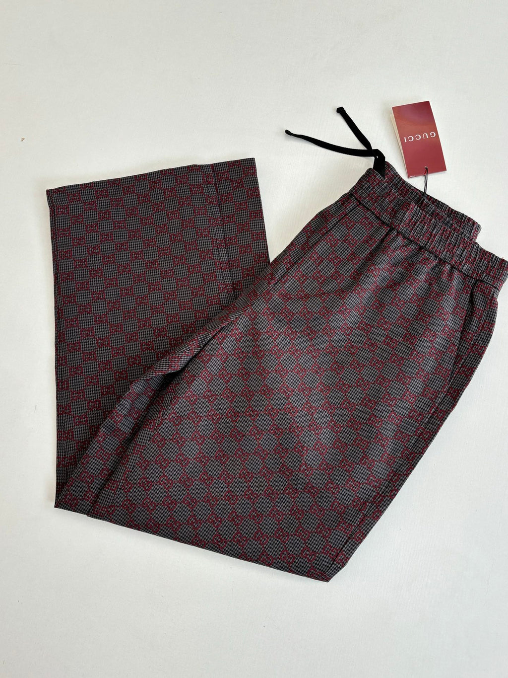 Gucci patterned long pants, elastic waistband and black drawstrings, folded