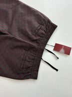 Gucci pants cuff detail with elastic hem and black drawstrings, folded