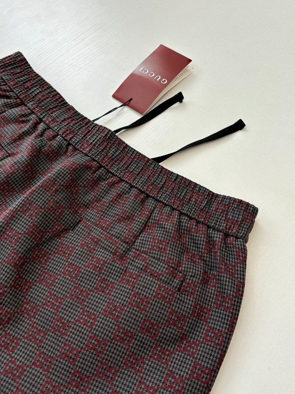 Gucci patterned pants with elastic waistband and drawstring ties, folded